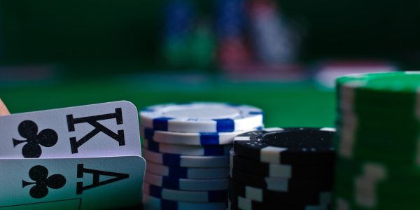 Close-up of playing cards and poker chips on a green felt table